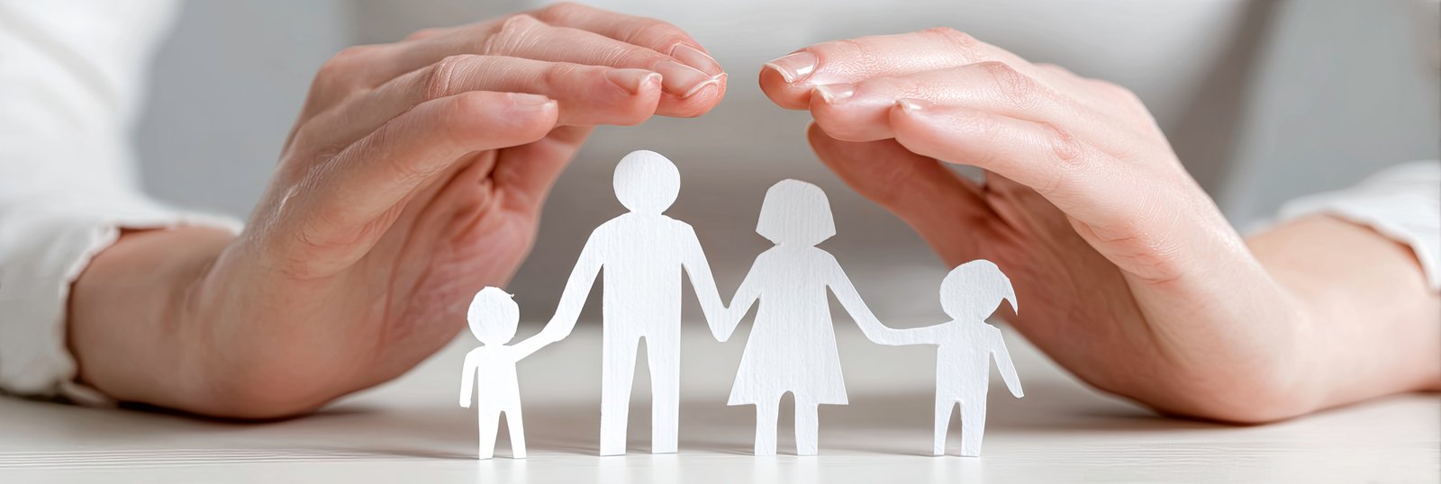 A business professional in a suit holding a small paper cutout family protected under a miniature purple umbrella, representing life and family insurance